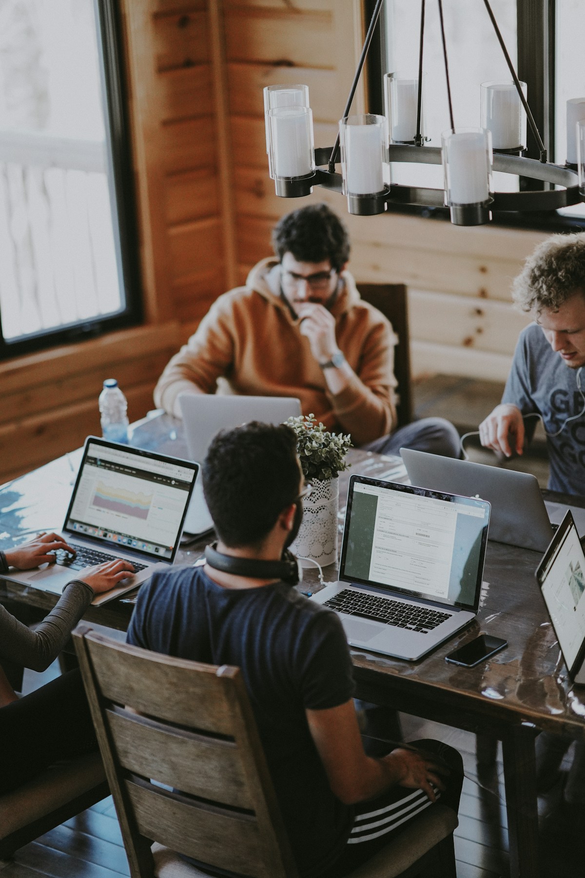 People collaborating around laptops in a shared workspace